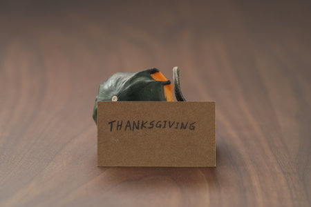 Decorative small pumpkin on wood table with thanksgiving greeting cardの写真素材