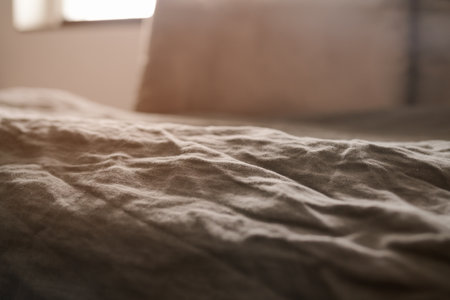 brown crumpled linen bed cover with sunlight from window