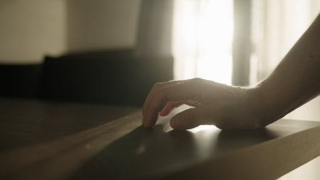 Man finger tap on walnut wood table indoorの写真素材