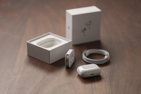 Saint-Petersburg, Russia - Circa December, 2022: Apple AirPods Pro 2nd generation unboxing photo on walnut tableのeditorial素材