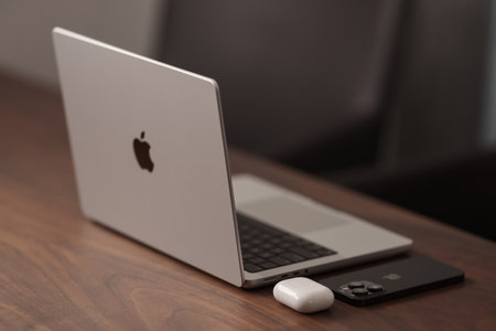 Saint-Petersburg, Russia - Circa December, 2022: open apple macbook pro 14 inch with iphone 14 pro space black on walnut tableのeditorial素材