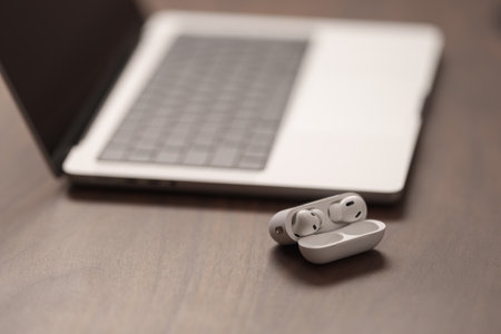 Saint-Petersburg, Russia - Circa December, 2022: open apple macbook pro 14 inch with airpods black on walnut tableのeditorial素材