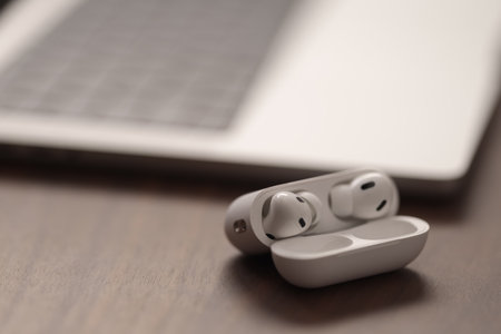 Saint-Petersburg, Russia - Circa December, 2022: open apple macbook pro 14 inch with airpods black on walnut tableのeditorial素材