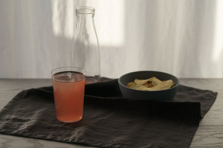 Pink drink with potato chips in a bowl on linen napkin