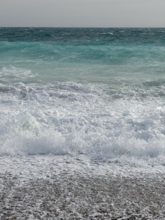 Pebble beach of Nice, France with azure waves of mediterranean seaの写真素材
