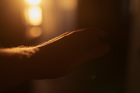 Abstract man hand playing with sunset light indoorの写真素材