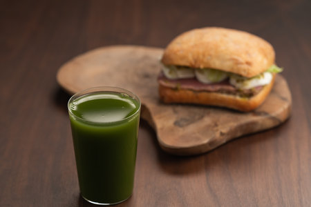 Green matcha drink in tumbler glass with sandwich on backgroundの写真素材