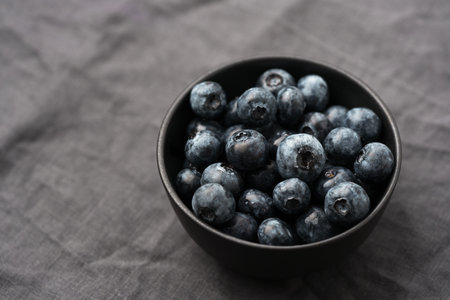 Freshly washed organic blueberries in a black bowl closeupの写真素材