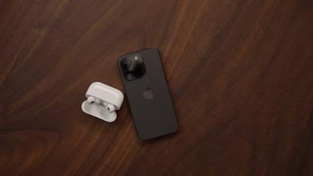 Saint-Petersburg, Russia - Circa December, 2022: iPhone 14 Pro Space Black with airpods pro 2 on walnut tableのeditorial素材