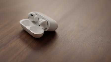 Saint-Petersburg, Russia - Circa December, 2022: Apple AirPods Pro 2nd generation on walnut table