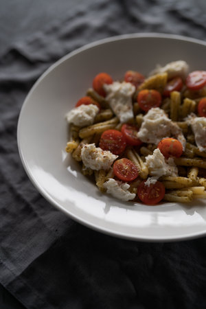 casarecce pasta with pesto, fresh cherry tomatoes and mozzarellaの写真素材