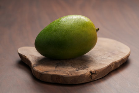 Ripe green mango washed and ready to eat on wood boardの写真素材