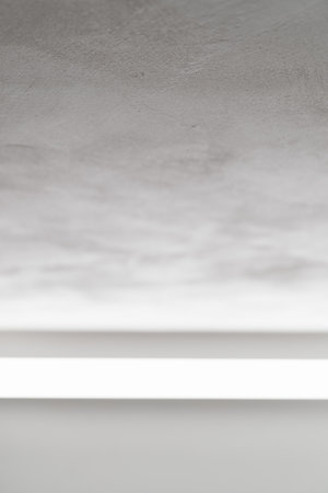 Abstract photo of white wall with light reflection from a light barの写真素材