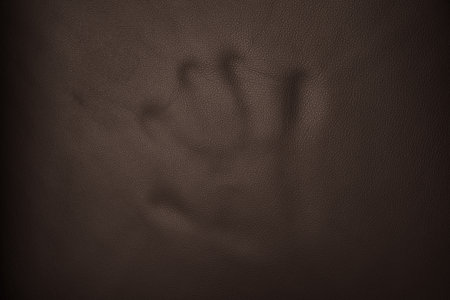 Full grain brown leather background with hand markの写真素材