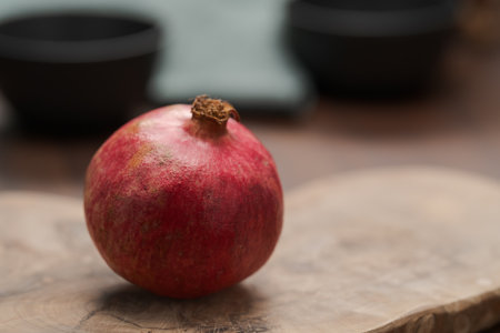 Ripe small pomegrenate on olive wood board