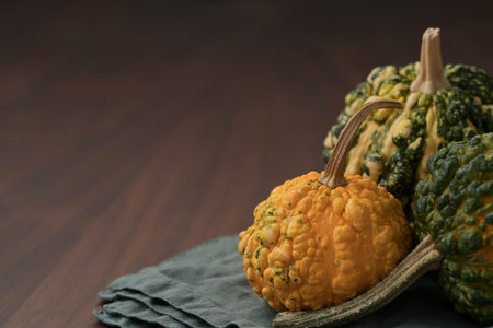 decorative pumpkins on a napkin on a walnut wood tableの写真素材