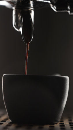 vertical shot pulling espresso shot with single spout portafilter from coffee machine closeupの写真素材