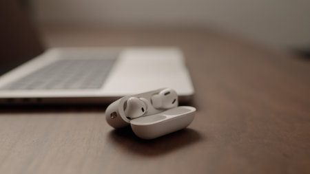 Saint-Petersburg, Russia - Circa December, 2022: open apple macbook pro 14 inch with airpods black on walnut tableのeditorial素材