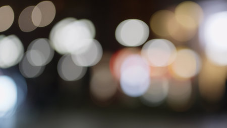 Bokeh background of night city with car light passing by