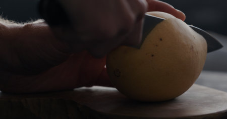 man cut thailand mango on olive board closeupの写真素材