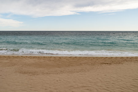 Empty sand beach on Mediterranean sea with horizon line vacation background