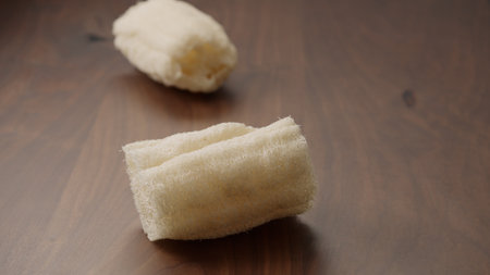 Loofah sponge on walnut wood table,   shotの写真素材