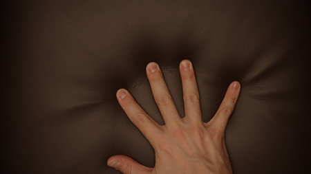 Man hand checking dark brown leather cushion closeupの写真素材