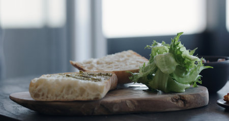 man making ciabatta sandwich with shrimps, olives and pestoの写真素材