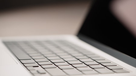 Saint-Petersburg, Russia - Circa December, 2022: Closeup of keyboard on open apple macbook pro 14 inch on walnut tableのeditorial素材