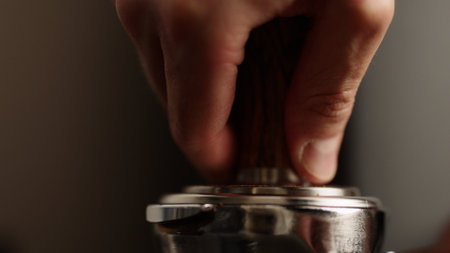closeup of tamping fresh ground coffee in portafilterの写真素材