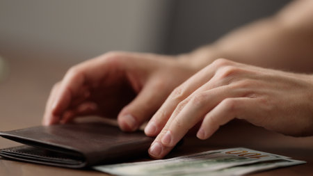 closeup man counting money in brown leather walletの写真素材