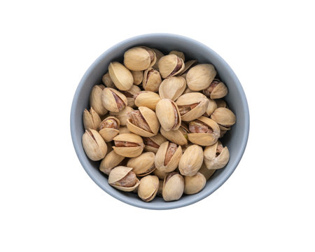 Top view of salted pistachios in blue bowl isolated on white backgroundの写真素材