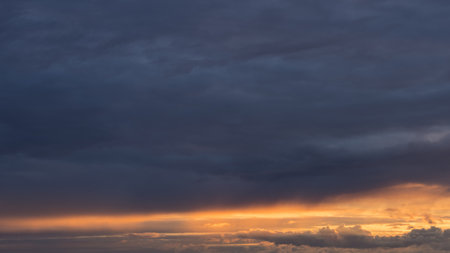Dramatic yellow sunset with vibrant clouds lit by a sun