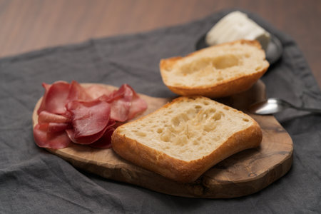 Ingredients for sandwich with bresaola, pesto and balsamic on olive boardの写真素材