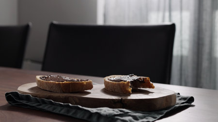 Rustic bread with organic hazelnut chocolate spread on olive boardの写真素材