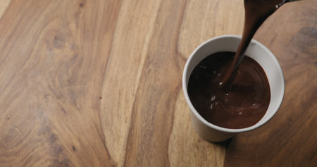 pour hot cocoa in paper cup on wood background with copy spaceの写真素材