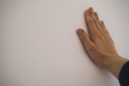 closeup young man hand touching plastered wallの写真素材