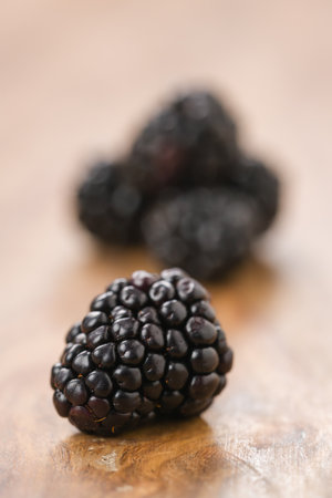 Closeup ripe blackberries on wood background