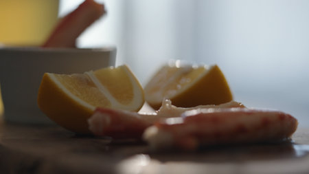 Crab leg meat on a olive board with sweet lemon and dip sauce on concrete countertopの写真素材