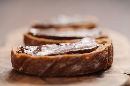 Ciabatta slices with chocolate spread on olive wood boardの写真素材