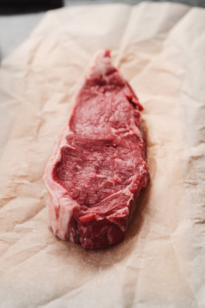 Raw new york sirloin steak on parchment paper warming up before cookingの写真素材