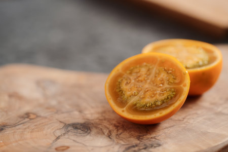 Lulo fruit sliced in halves on olive wood board on kitchen countertopの写真素材