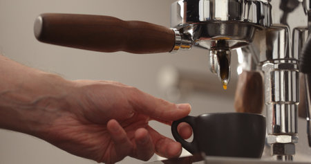 espresso pour from single spout portafilter into black cupの写真素材
