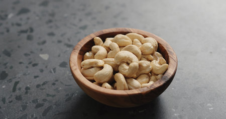 cashew nuts in olive bowl on terrazzo countertopの写真素材