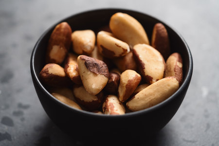 brazil nuts in black bowl on terrazzo countertopの写真素材