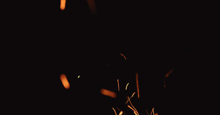 hot sparks from charcoal moving up on black background