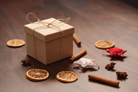 Christmas gift box from eco friendly paper wrapped with natural twine on wood table with natural decorationsの写真素材