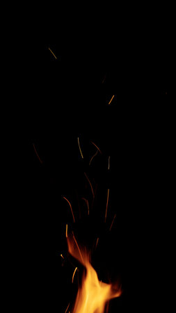 fire flames of campfire with sparks over black background, for overlay