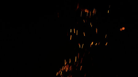 sparks and embers from campfire flying over black backgroundの写真素材