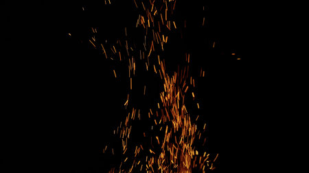 sparks and embers from campfire flying over black backgroundの写真素材